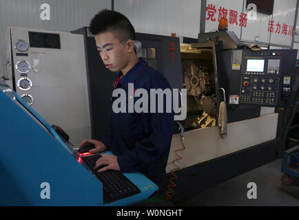 Eine Chinesische Techniker überwacht die präzises Bohren der Luftfahrt Gasturbine Komponenten durch Software-gesteuerte Maschinen Hanyu der Produktionsstätte in Zigong, Provinz Sichuan, am 16. November 2017. Hanyu produziert Schlüsselkomponenten für Luftfahrt und Gasturbinenschaufeln, von denen einige militärische sind ab und sind in die Vereinigten Staaten exportiert. Foto von Stephen Rasierer/UPI Stockfoto