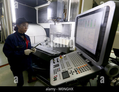 Eine Chinesische Techniker überwacht die präzises Bohren der Luftfahrt Gasturbine Komponenten durch Software-gesteuerte Maschinen Hanyu der Produktionsstätte in Zigong, Provinz Sichuan, am 16. November 2017. Hanyu produziert Schlüsselkomponenten für Luftfahrt und Gasturbinenschaufeln, von denen einige militärische sind ab und sind in die Vereinigten Staaten exportiert. Foto von Stephen Rasierer/UPI Stockfoto