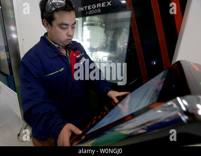 Eine Chinesische Techniker überwacht die präzises Bohren der Luftfahrt Gasturbine Komponenten durch Software-gesteuerte Maschinen Hanyu der Produktionsstätte in Zigong, Provinz Sichuan, am 16. November 2017. Hanyu produziert Schlüsselkomponenten für Luftfahrt und Gasturbinenschaufeln, von denen einige militärische sind ab und sind in die Vereinigten Staaten exportiert. Foto von Stephen Rasierer/UPI Stockfoto