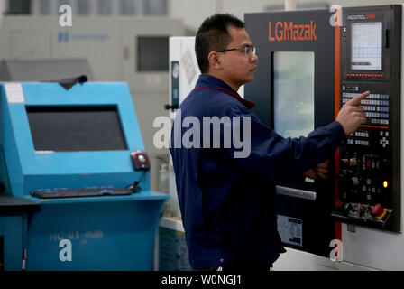 Eine Chinesische Techniker überwacht die präzises Bohren der Luftfahrt Gasturbine Komponenten durch Software-gesteuerte Maschinen Hanyu der Produktionsstätte in Zigong, Provinz Sichuan, am 16. November 2017. Hanyu produziert Schlüsselkomponenten für Luftfahrt und Gasturbinenschaufeln, von denen einige militärische sind ab und sind in die Vereinigten Staaten exportiert. Foto von Stephen Rasierer/UPI Stockfoto