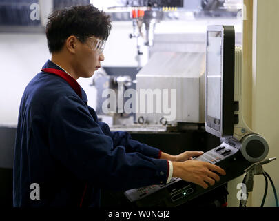 Eine Chinesische Techniker überwacht die präzises Bohren der Luftfahrt Gasturbine Komponenten durch Software-gesteuerte Maschinen Hanyu der Produktionsstätte in Zigong, Provinz Sichuan, am 16. November 2017. Hanyu produziert Schlüsselkomponenten für Luftfahrt und Gasturbinenschaufeln, von denen einige militärische sind ab und sind in die Vereinigten Staaten exportiert. Foto von Stephen Rasierer/UPI Stockfoto