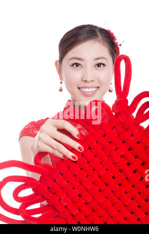 Junge asiatische Frau in Rot cheongsam hält rote chinesische Knoten in das chinesische Neujahr Stockfoto
