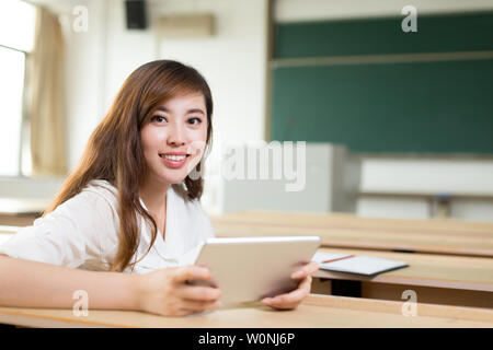 Asiatische schöne Frau mit Tablette im Klassenzimmer Stockfoto