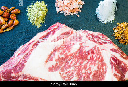 Eine Scheibe frischen, rohen Steak, bunten Gewürzen und Salz. Stockfoto