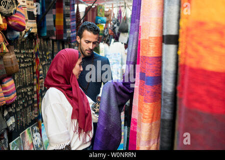 Lächelnden jungen muslimischen Paar Einkaufen und Teppiche in einem textilgeschäft Stockfoto