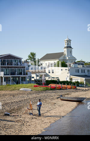 Provincetown, MA - 11. Juni 2019: Künstler ist Malen mit seine Staffelei auf dem Strand. Provincetown ist seit langem bekannt als eine Gemeinschaft von Künstlern und Stockfoto