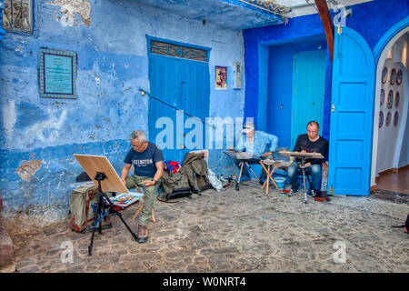 Chefchaouen, Marokko - Mai 03, 2019: asiatische Touristen Malerei Bilder auf einer wunderschönen Straße in der touristischen Stadt Chefchaouen in Nordmarokko Stockfoto