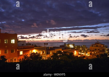 Sonnenuntergang Stimmung in stark bewoelkt, mit spektakulären Farbe und Licht über dem Atlantik und mit Blick auf einen teilweisen Blick auf die Stadt von Puerto d Stockfoto