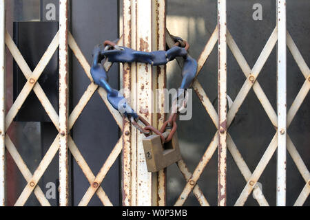 Altes großes Vorhängeschloss an der Kette mit geschlossenen Metal Gate Stockfoto