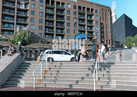 Am 22. Juni 2019 genießen Besucher die öffentlichen Bereiche am Ostufer der Cleveland Flats in der Innenstadt von Cleveland, Ohio, USA. Stockfoto