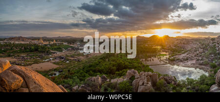 Ein Blick über Hampi mit seinen Tempeln, Flüsse und Reisfelder, bei Sonnenuntergang. Stockfoto