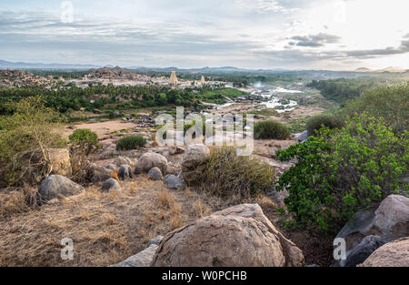 Ein Blick über Hampi mit seinen Tempeln, Flüsse und Reisfelder, bei Sonnenuntergang. Stockfoto