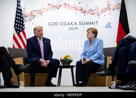 Osaka, Japan. 28 Juni, 2019. Bundeskanzlerin Angela Merkel (r, CDU) und Donald Trump, Präsident der Vereinigten Staaten von Amerika (USA), am Rande des G20-Gipfels zu Gesprächen treffen. Die Staats- und Regierungschefs der 19 führenden Industrieländern und aufstrebenden Ländern und der Europäischen Union treffen sich auf dem G20-Gipfel in Osaka (Japan) am 28. und 29. Juni 2019. Quelle: Bernd von Jutrczenka/dpa/Alamy leben Nachrichten Stockfoto