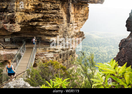 Katoomba, New South Wales, Australien - 13. Februar 2019: Brücke Bildung drei Schwestern mit Wanderer in der sunshined Tal auf der Suche nach Rock Stockfoto