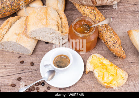 Blick von oben auf ein sehr leichtes Frühstück. hausgemachtes Brot mit Marmelade und ein Espresso. Stockfoto