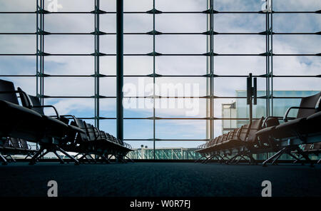 Die Sitze in der Abflughalle am Flughafen Terminal. Innenraum der Flughafen Terminal. Die Stühle im Abflugbereich auf internationaler Tor. Verkehr Stockfoto