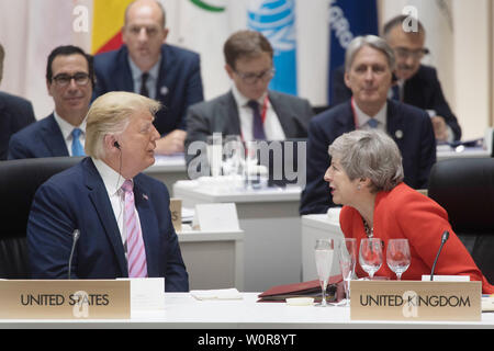 US-Präsident Donald Trump Chats mit dem britischen Premierminister Theresa kann bei der ersten Arbeitssitzung der G20-Gipfel in Osaka, Japan. Stockfoto