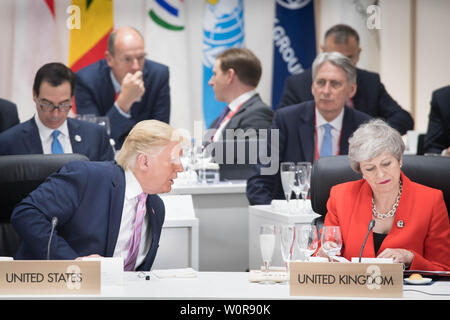 US-Präsident Donald Trump Chats mit dem britischen Premierminister Theresa kann bei der ersten Arbeitssitzung der G20-Gipfel in Osaka, Japan. Stockfoto