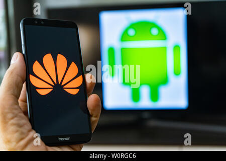 Magdeburg Deutschland - Juni 2019: ein Mann hält ein Android Smartphone Ehren. Auf dem Bildschirm, die huawei Logo vor der Android Logo. Google beschränken Stockfoto