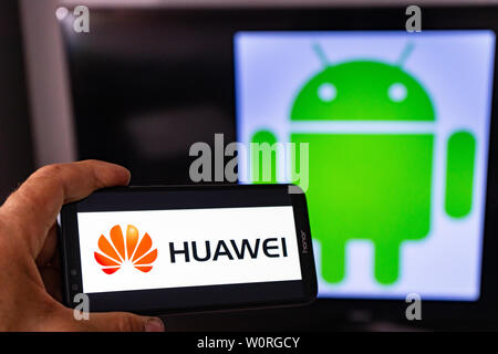 Magdeburg Deutschland - Juni 2019: ein Mann hält ein Android Smartphone Ehren. Auf dem Bildschirm, die huawei Logo vor der Android Logo. Google beschränken Stockfoto