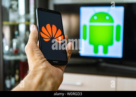 Magdeburg Deutschland - Juni 2019: ein Mann hält ein Android Smartphone Ehren. Auf dem Bildschirm, die huawei Logo vor der Android Logo. Google beschränken Stockfoto