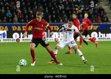 V. LI. im Zweikampf zwischen Nils Petersen (Freiburg) mit Ball, Charles Aranguiz (Bayer 04 Leverkusen), 1. BL: 17-18 - 21. Spieltag - SC Freiburg gegen Bayer 04 Leverkusen. Stockfoto