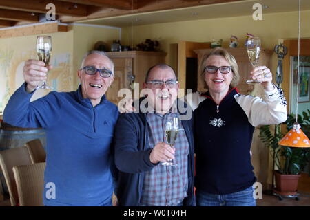 Im heimischen Hotel Sonnenhof ein Prosit in Bronze: v. li. Vater Charly Doll, Franz Lickert, Vorsitzender der SZ Breitnau, Mutter Friederike Puppe stoßen mit Sekt auf den großen Erfolg von Benedikt Doll ein - Olympische Winterspiele PyeongChang - Biathlon Verfolgung Herren Stockfoto