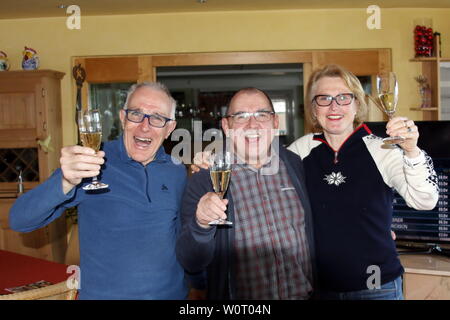 Überschäumende Freude im heimischen Hotel Sonnenhof ein Prosit in Bronze: v. li. Vater Charly Doll, Franz Lickert, Vorsitzender der SZ Breitnau, Mutter Friederike Puppe stoßen mit Sekt auf den großen Erfolg von Benedikt Doll ein - Olympische Winterspiele PyeongChang - Biathlon Verfolgung Herren Stockfoto