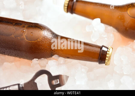 Zwei Bierflaschen auf Crushed Ice mit Flaschenöffner. Horizontale Komposition. Top erhöhten anzeigen. Stockfoto