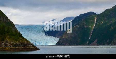 Ferner Panoramablick auf ein Holgate Gletschers mit Wasserfall auf der Seite in den Kenai Fjords National Park Seward, Alaska, USA, Nordamerika. Stockfoto