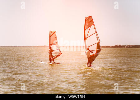 Romantik im Meer Paar Mann und Frau zusammen segeln auf einem Windsurfbrett während auf Ferien im Süden Stockfoto