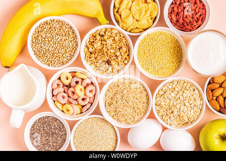 Zutaten für gesundes Frühstück - Müsli, Getreide, Milchprodukte, Samen, Nüssen und Früchten. Stockfoto