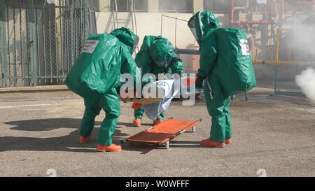 Feuerwehrmänner dressing schützende Suiten rescue berauscht Mannequins aus undichten giftig medizinische Gase in Haemek Krankenhaus während bohren. Afula, Israel, 30. Januar 2017 Stockfoto