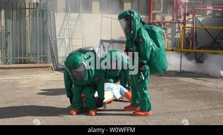 Feuerwehrmänner dressing schützende Suiten rescue berauscht Mannequins aus undichten giftig medizinische Gase in Haemek Krankenhaus während bohren. Afula, Israel, 30. Januar 2017 Stockfoto