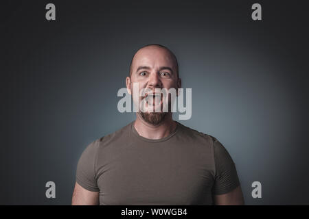 Portrait der kaukasischen Menschen schreien und Suchen gerade vor der Kamera, trug ein T-Shirt, Studio gedreht. Stockfoto