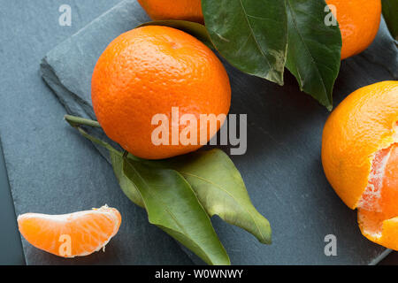 Orange mandarin Früchte auf dem schwarzen Schiefer platte Hintergrund. Selektiver Fokus Stockfoto