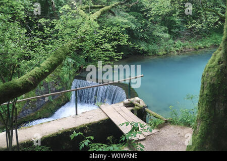 Erstaunlich schöne Bergquelle mit himmlischen blauen Wasser Farbe und kleinen Wasserfall namens Krupajsko Vrelo (Frühjahr Krupaj) Stockfoto