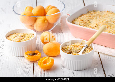 Crumble mit Aprikosen und Zimt am Tisch serviert Stockfoto