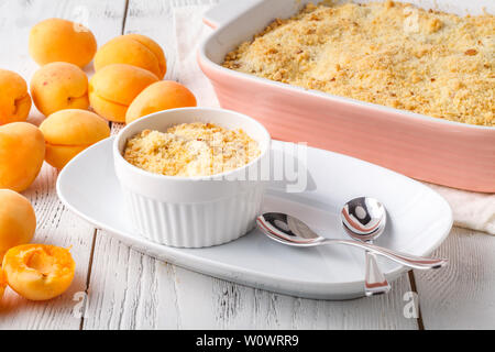 Crumble mit Aprikosen und Zimt am Tisch serviert Stockfoto