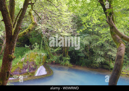 Erstaunlich schöne Bergquelle mit himmlischen blauen Wasser Farbe und kleinen Wasserfall namens Krupajsko Vrelo (Frühjahr Krupaj) Stockfoto