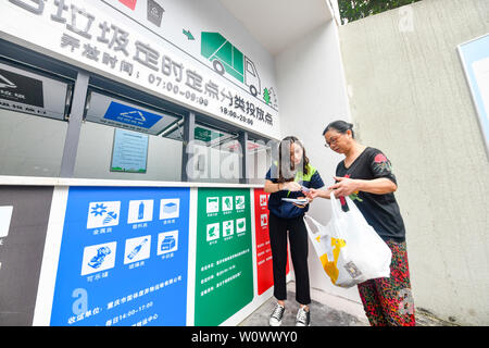 Chongqing, China. 27 Juni, 2019. Garbage Klassifizierung Inspector von Chongqing Umwelt & Hygiene Gruppe Lu Xing (L) bietet Beratung Service Abfall Klassifizierung auf eine Resident an eine Gemeinde im Bezirk Jiulongpo in Chongqing, im Südwesten von China, 27. Juni 2019. Chongqing hat sich bemüht, Müll sortieren in den letzten Jahren zu fördern. Eine garbage Klassifizierungssystem hat 680.000 Haushalte von 1.796 Gemeinden in 39 Straßen und Orte in der Innenstadt von Chongqing abgedeckt. Credit: Liu Chan/Xinhua/Alamy leben Nachrichten Stockfoto