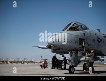 Eine A-10 Thunderbolt II des 86th Waffen Geschwader zugewiesen bereitet mit Hilfe der ersten Wartung Support Service Team an der Nellis Air Force Base, Nev, Juni 21, 2019 zu starten. Piloten den 6 Combat Training Squadron und 66th Waffen Geschwader zugewiesen eine Überführung in 2nd Lieutenant James Lord's Begräbnis war ein Weltkrieg II P-47 Thunderbolt Pilot, der nach Hause nach verbleibenden in POW/MIA Status für mehr als 70 Jahre zurück. (U.S. Air Force Foto von Airman 1st Class Bryan Guthrie) Stockfoto