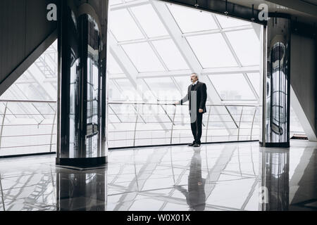 Ernsthafte ältere Mann in großen Office Center Stockfoto