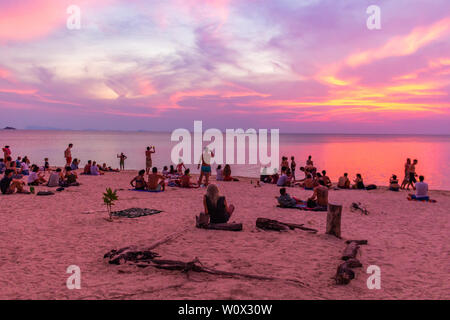 Koh Phangan, Thailand - 26 April 2019: Gast sitzt auf dem Sand und den Sonnenuntergang am Strand von Sri Thanu Zen Stockfoto