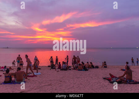 Koh Phangan, Thailand - 26 April 2019: Gast sitzt auf dem Sand und den Sonnenuntergang am Strand von Sri Thanu Zen Stockfoto