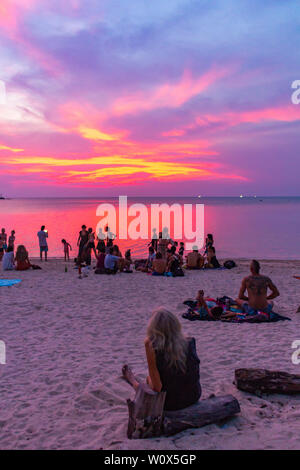 Koh Phangan, Thailand - 26 April 2019: Gast sitzt auf dem Sand und den Sonnenuntergang am Strand von Sri Thanu Zen Stockfoto