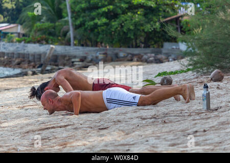 Koh Phangan, Thailand - 27 April, 2019: Zwei Männer am Sport, am Strand bei Sonnenaufgang auf Koh Phangan Island Stockfoto