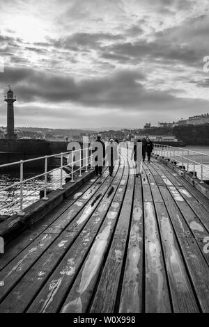 Whitby Hafen Hafen Wand Holzbrücke shot in Schwarz und Weiß an einem bewölkten Tag Winter Stockfoto