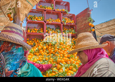 Oued Laou, Tetouan, Marokko - 4. Mai 2019: Marokkanische Frauen kaufen Orangen im Souk von Oued Laou, wo jeden Samstag einen traditionellen Markt eingerichtet ist Stockfoto