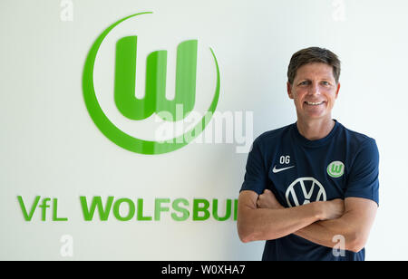 28. Juni 2019, Niedersachsen, Wolfsburg: Oliver Glasner, der neue Trainer des VfL Wolfsburg, der Bundesliga Fußball-Team, lächelt, neben dem Wappen der Club der Arme während seiner Präsentation. Foto: Peter Steffen/dpa - WICHTIGER HINWEIS: In Übereinstimmung mit den Anforderungen der DFL Deutsche Fußball Liga oder der DFB Deutscher Fußball-Bund ist es untersagt, zu verwenden oder verwendet Fotos im Stadion und/oder das Spiel in Form von Bildern und/oder Videos - wie Foto Sequenzen getroffen haben. Stockfoto